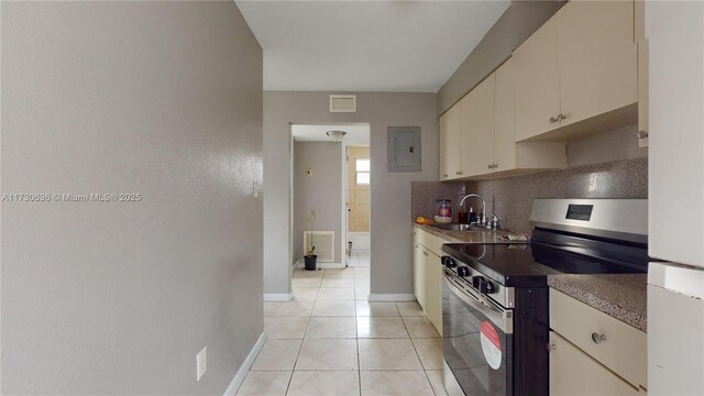 kitchen featuring sink, electric panel, tasteful backsplash, light tile patterned flooring, and stainless steel range with electric cooktop