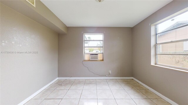 tiled empty room with cooling unit and a wealth of natural light