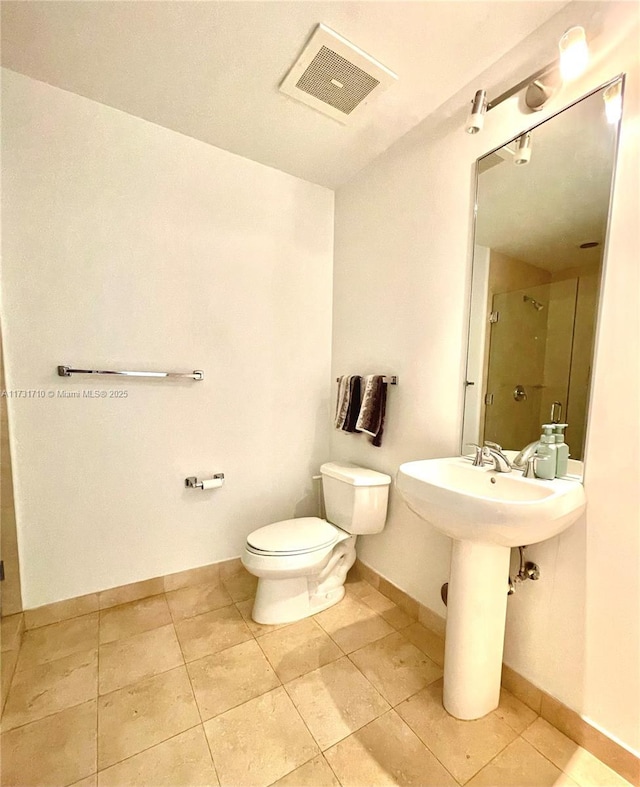 bathroom featuring walk in shower, sink, toilet, and tile patterned flooring