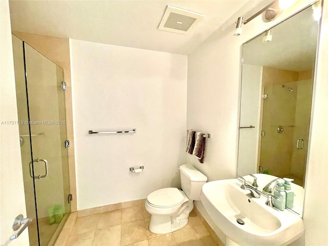 bathroom featuring tile patterned flooring, sink, a shower with shower door, and toilet