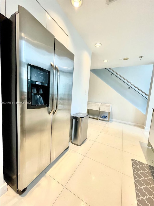 kitchen with stainless steel refrigerator with ice dispenser, white cabinets, and light tile patterned floors