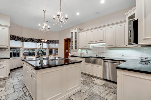 kitchen with sink, hanging light fixtures, a kitchen island, and white cabinets