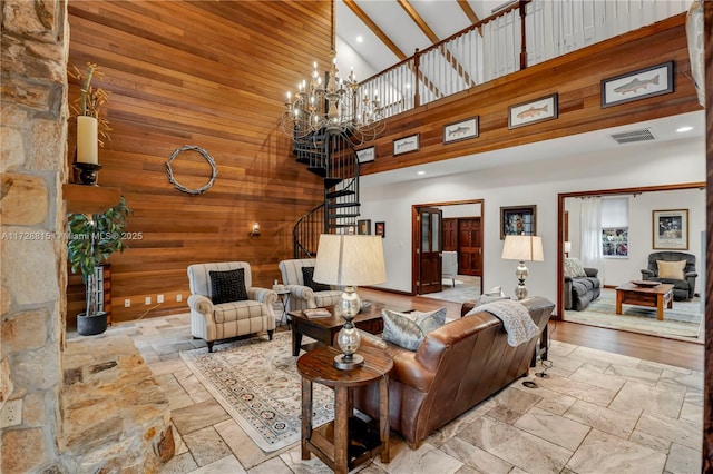 living room with beamed ceiling, wooden walls, an inviting chandelier, and high vaulted ceiling