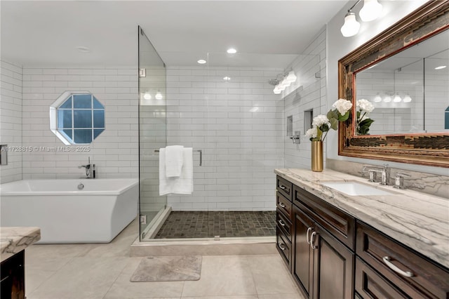 bathroom with vanity, tile patterned flooring, shower with separate bathtub, and tile walls