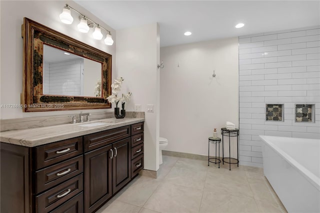 bathroom with toilet, tile patterned floors, vanity, and a bath