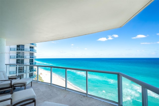 balcony featuring a water view and a view of the beach