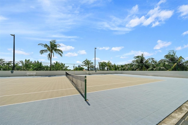 view of tennis court with basketball hoop