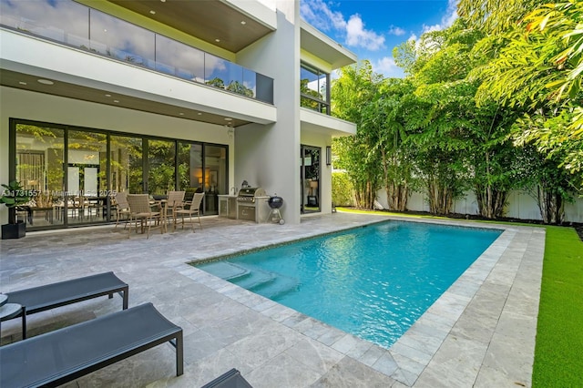 view of pool featuring area for grilling and a patio