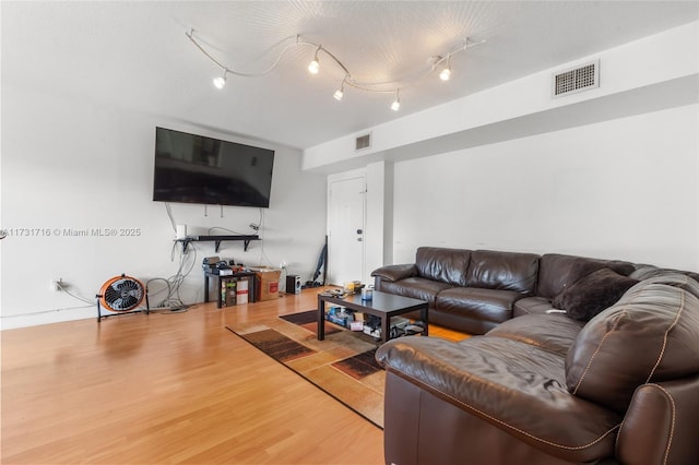 living area with wood finished floors, visible vents, and rail lighting