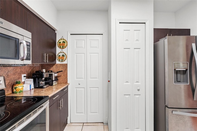 kitchen with stainless steel appliances, light tile patterned flooring, dark brown cabinets, and tasteful backsplash