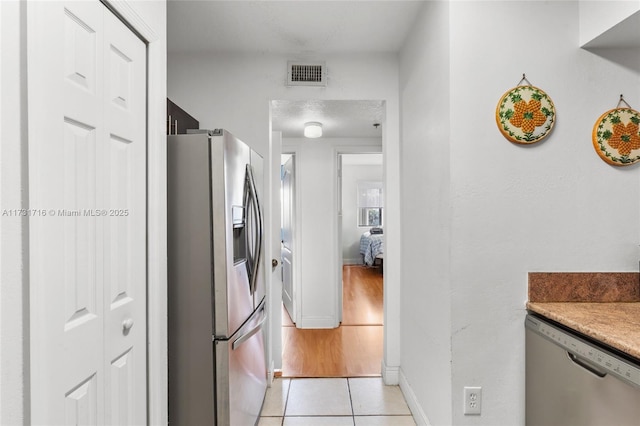 kitchen featuring light tile patterned floors, light countertops, visible vents, appliances with stainless steel finishes, and baseboards