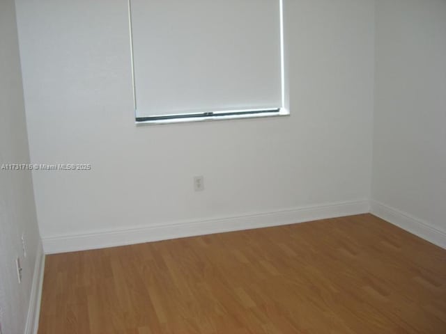 empty room featuring baseboards and wood finished floors