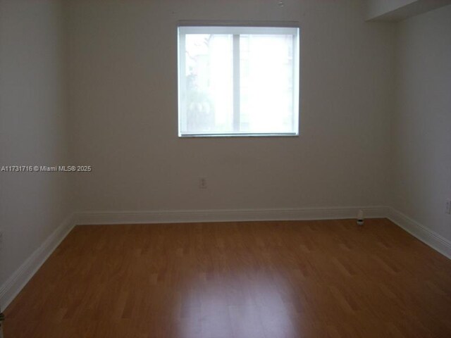 empty room with wood finished floors and baseboards