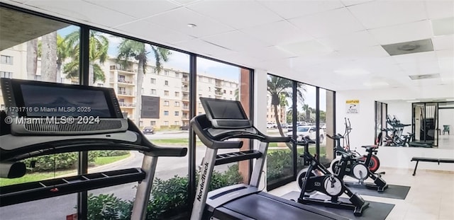 workout area featuring expansive windows and a drop ceiling