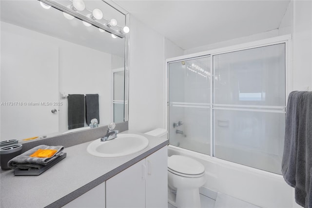 full bathroom featuring toilet, tile patterned floors, vanity, and bath / shower combo with glass door