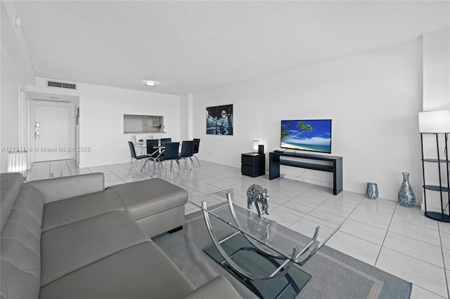 living room featuring a textured ceiling and light tile patterned floors