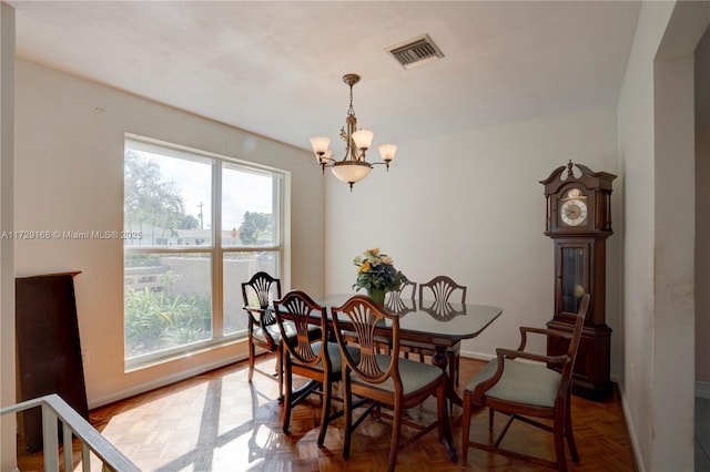 dining space featuring an inviting chandelier and parquet floors