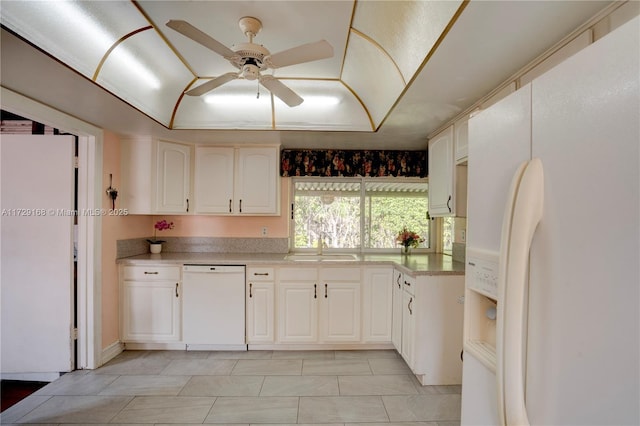 kitchen featuring sink, white cabinets, ceiling fan, a tray ceiling, and white appliances