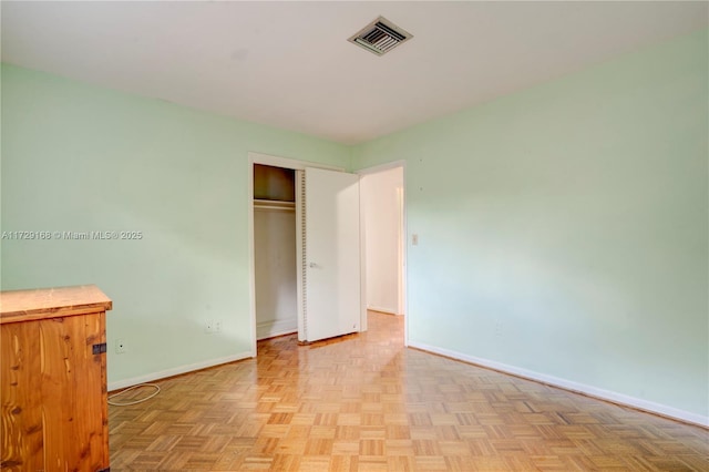 unfurnished bedroom with light parquet floors and a closet