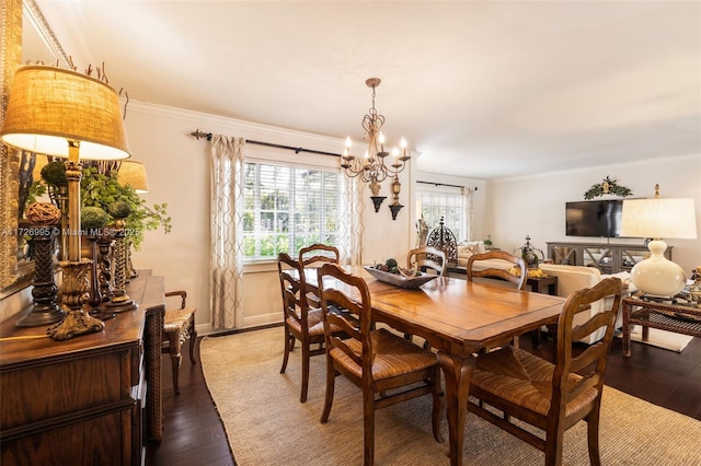 dining area featuring crown molding, wood-type flooring, and a notable chandelier