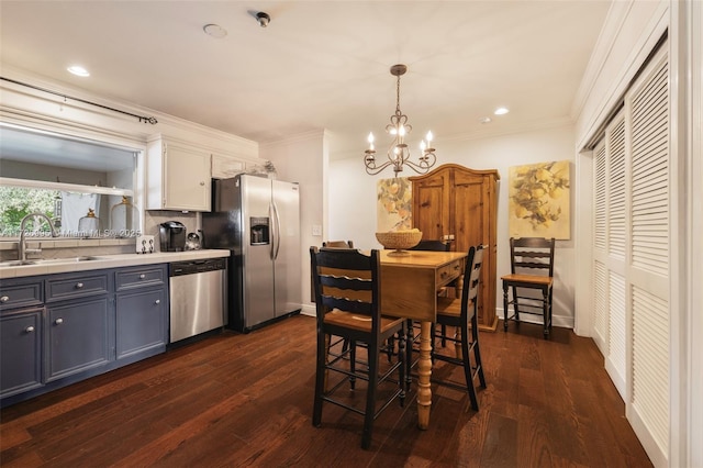 kitchen featuring sink, hanging light fixtures, stainless steel appliances, dark hardwood / wood-style floors, and white cabinets