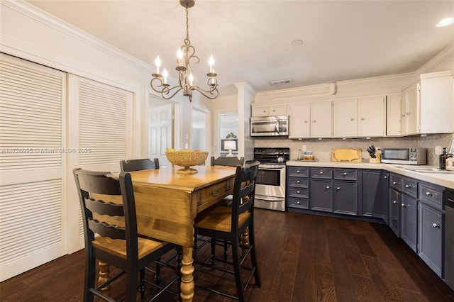 dining area featuring crown molding, dark hardwood / wood-style flooring, and an inviting chandelier