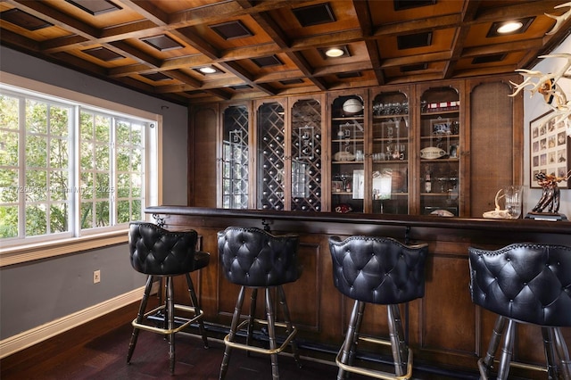 bar with beamed ceiling, coffered ceiling, and dark hardwood / wood-style floors