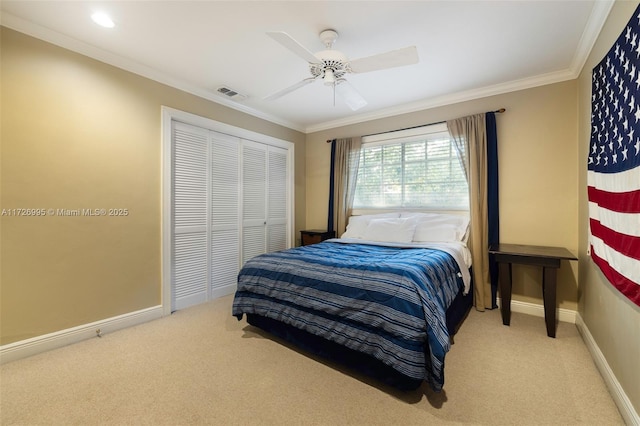 bedroom featuring ceiling fan, ornamental molding, carpet flooring, and a closet