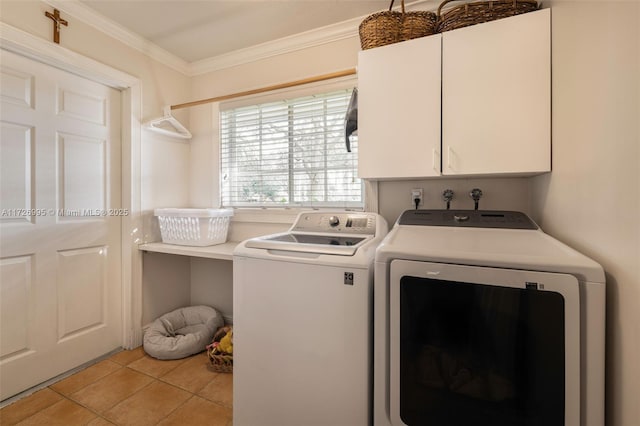 laundry area featuring cabinets, ornamental molding, washer and dryer, and light tile patterned floors