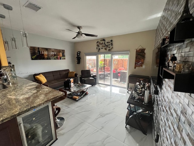 living room with wine cooler, ceiling fan, and sink