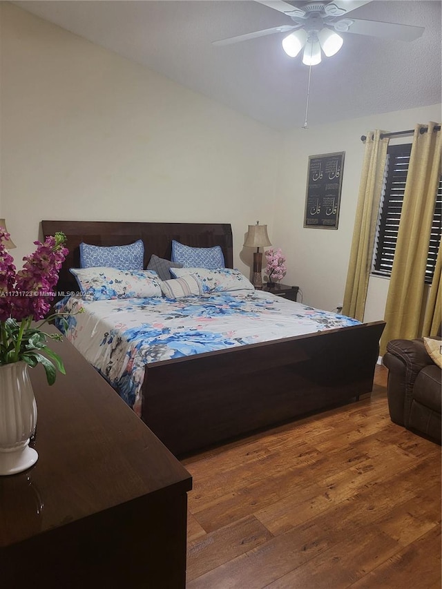 bedroom with dark hardwood / wood-style floors and ceiling fan