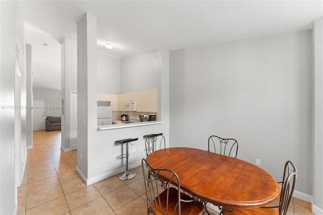 dining room with baseboards and light tile patterned floors