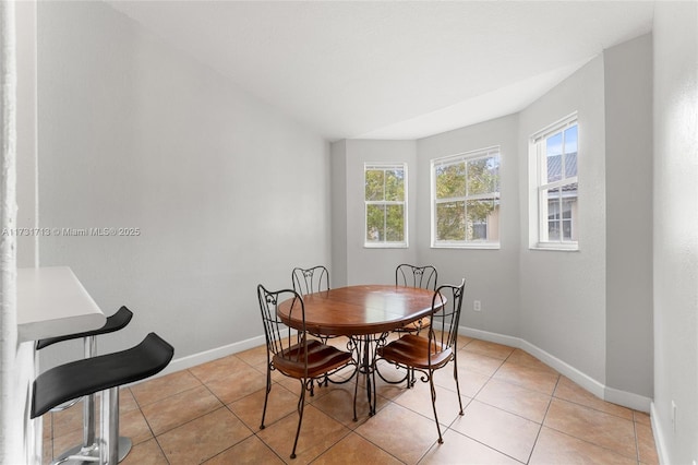 dining space with light tile patterned flooring and baseboards