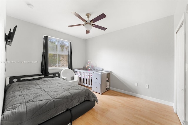 bedroom with ceiling fan, baseboards, and wood finished floors