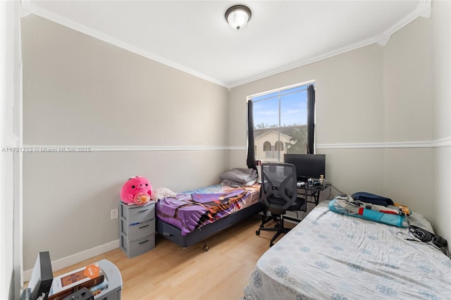 bedroom with ornamental molding, wood finished floors, and baseboards