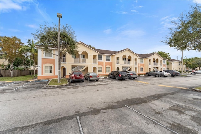 view of property with uncovered parking and fence