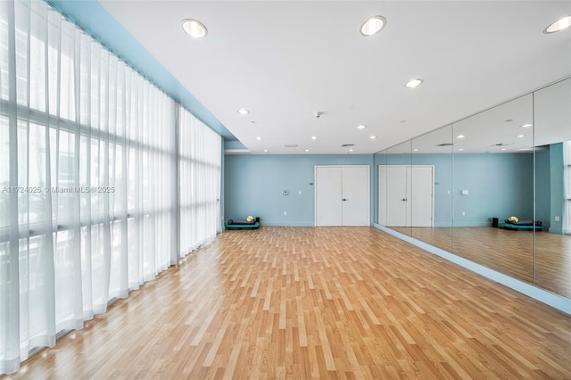 workout area with light hardwood / wood-style floors