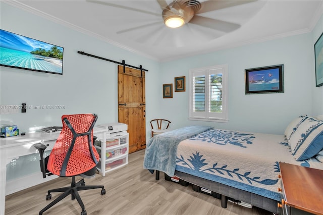 bedroom featuring light hardwood / wood-style flooring, ornamental molding, a barn door, and ceiling fan