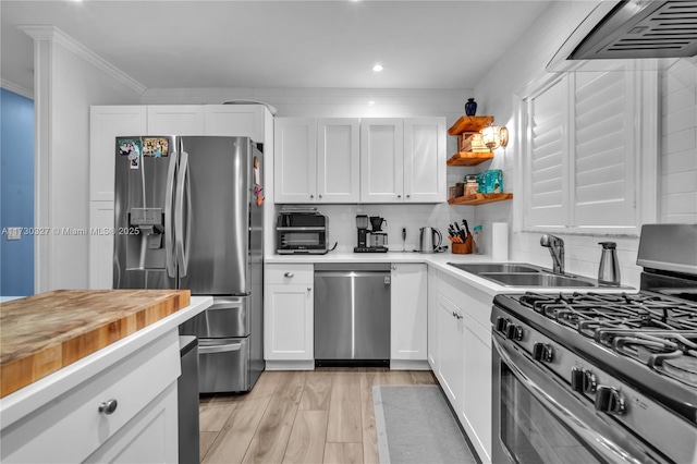 kitchen with sink, appliances with stainless steel finishes, tasteful backsplash, light hardwood / wood-style floors, and white cabinets