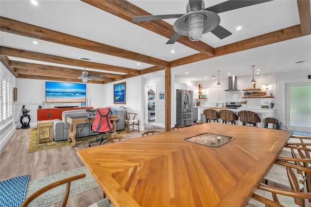 dining room featuring beamed ceiling, ceiling fan, and light hardwood / wood-style floors