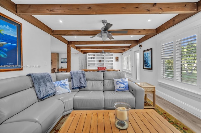 living room featuring beamed ceiling, hardwood / wood-style floors, and ceiling fan