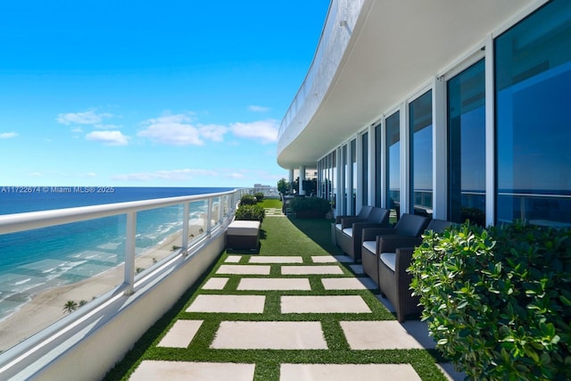 balcony with a water view and a view of the beach