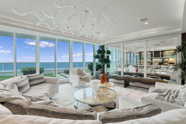 sunroom with a tray ceiling and a water view