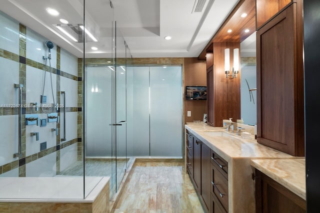 bathroom featuring visible vents, a stall shower, recessed lighting, a raised ceiling, and vanity