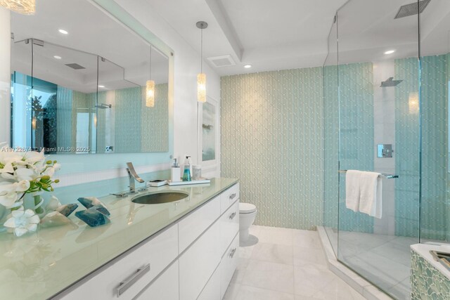 bathroom with vanity, toilet, tile patterned flooring, and a shower with door