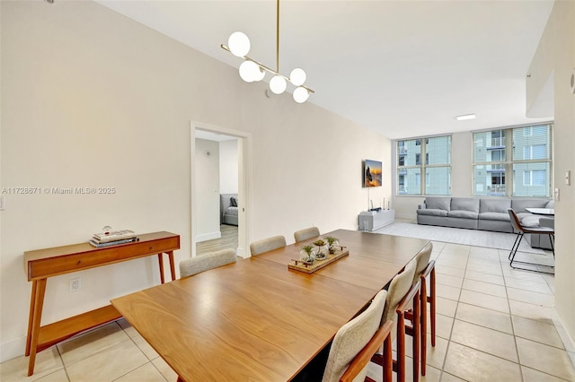 tiled dining room featuring an inviting chandelier