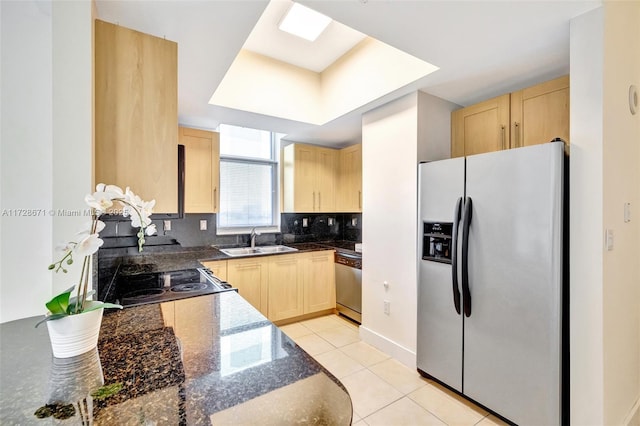 kitchen with light brown cabinetry, sink, light tile patterned floors, stainless steel appliances, and decorative backsplash