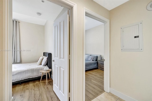 bedroom with light hardwood / wood-style flooring and electric panel