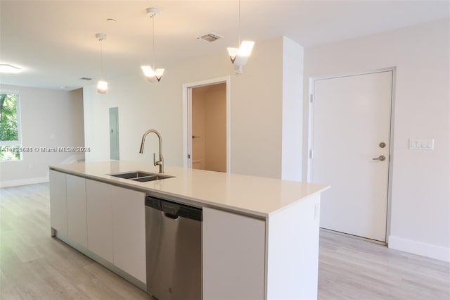 kitchen featuring sink, dishwasher, a kitchen island with sink, white cabinets, and decorative light fixtures