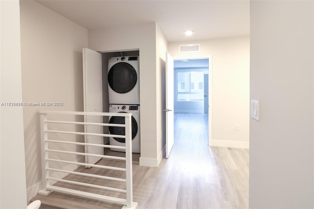 interior space featuring stacked washer and clothes dryer and light hardwood / wood-style flooring